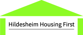 Ein einfacher grüner Umriss eines Hausdachs und von Wänden mit dem Text Hildesheim Housing First in der Mitte unter dem Dach.